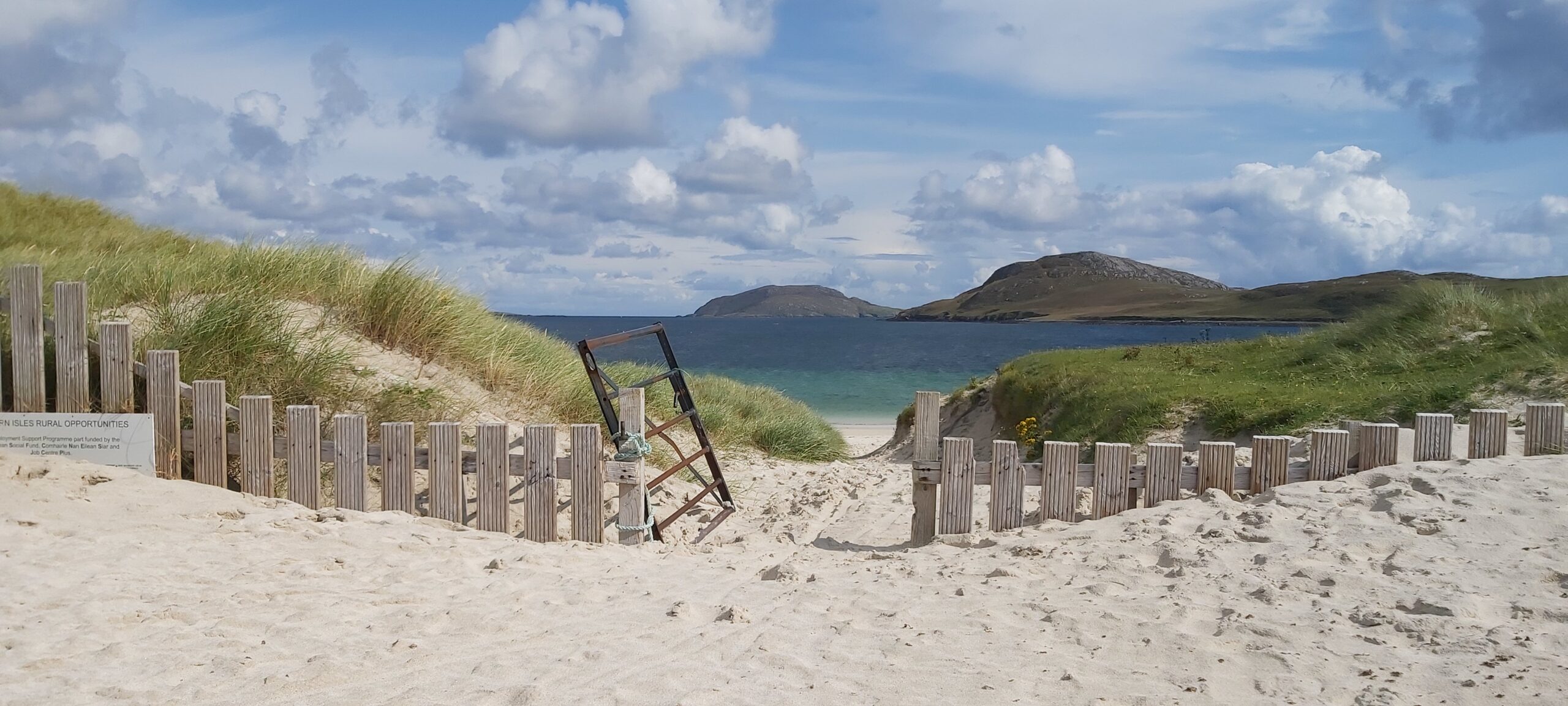 sandy beach with an open gate on the Isle of Barra